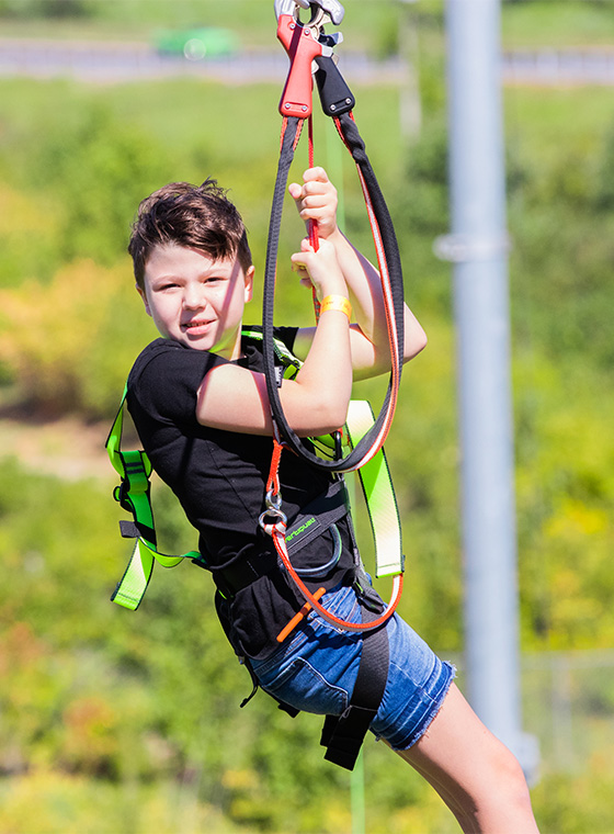 young boy ziplining at a birthday party
