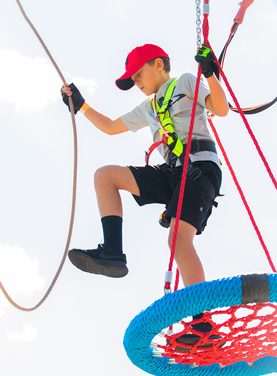 Young boy on obstacle and ropes course take a step