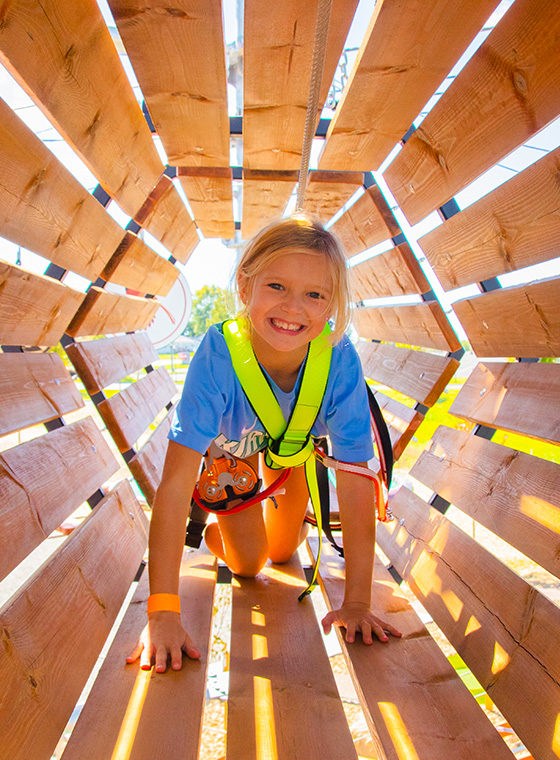 Young girl at a birthday party for kids climbing through tunnel